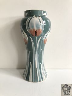 a green vase sitting on top of a white table