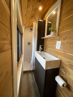 a small bathroom with wood walls and flooring