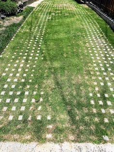 a lawn with white and black squares on it in the middle of a yard next to a fence