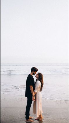 a man and woman kissing on the beach