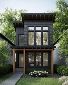 a black house with lots of windows in the front yard