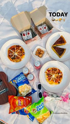 the picnic is ready to be eaten on the beach with snacks and drinks in paper plates