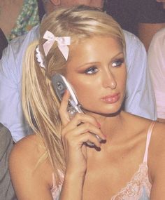 a woman talking on a cell phone while sitting in front of other people at a party