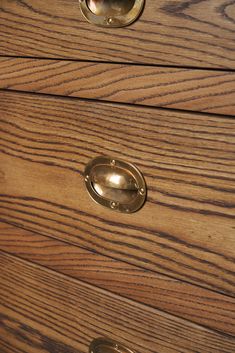 a wooden dresser with brass handles and knobs