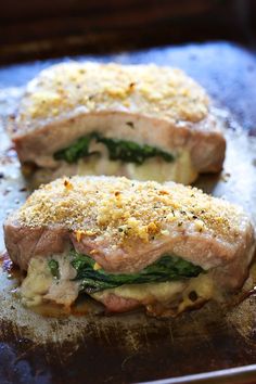 two pieces of meat covered in cheese and spinach