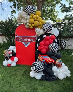 balloons and cars are on display in the grass