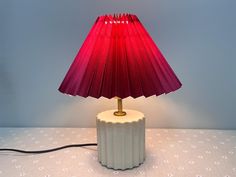 a red lamp sitting on top of a white table