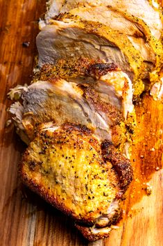 sliced pork on a cutting board with seasoning sprinkled around the top and sides