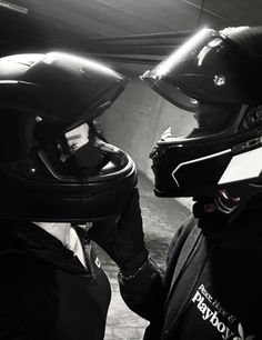 two people wearing helmets are talking to each other