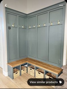 a corner bench with baskets under it in the middle of a room that is painted blue