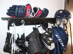 several pairs of hockey gear are hanging on a shelf