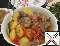 a bowl filled with meat and vegetables on top of a table next to other plates