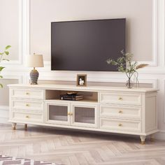 a large flat screen tv mounted to the side of a white entertainment center in a living room