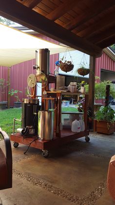 a cart full of pots and pans in a back yard with an awning over it