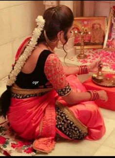 a woman sitting on the floor in front of a mirror with flowers and decorations around her