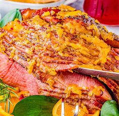 a large piece of meat on a platter with oranges and other food items