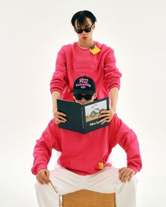 a woman sitting on top of a chair while reading a book