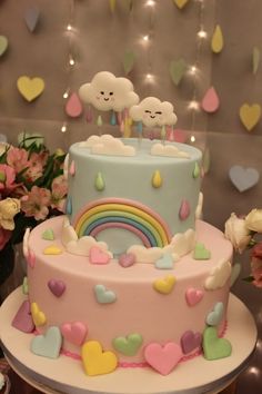 a multi layer cake with hearts and rainbows on the top is decorated in pastel colors