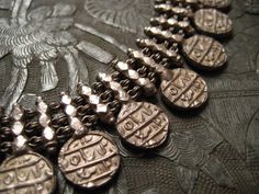 A very heavy antique 15" high grade silver necklace made of bars of cubic chunks, with a coin finial on every other bar on the sides and front, totalling 25. The wearable length of the necklace is closer to 14" due to the way it curves when worn Each coin is 10-11mm and looks like the 18th Century Mughal coins from India. Because the coins appear to be fairly similar, I assume they are not genuine period coins, instead that one coin has been cast and multiples produced to adorn the piece of jewellery. Whether originals or castings, the finished piece is very beautiful. The necklaces closes with a screw style pin. As pictured, it does screw clean out of the catch, so be careful not to lose it! Weighs around 4 oz. Arabic Script, Collar Choker, Necklace Collar, One Coin, Ethnic Design, Wood Cut, Choker Style, Old Coins, Choker Collar