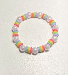 a bracelet with white beads and multicolored plastic beads on a white table top