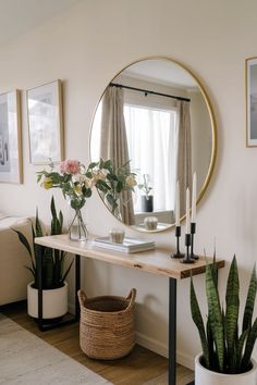 a living room with plants and a large round mirror on the wall over a table