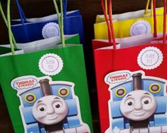 three thomas the tank engine bags with tags on each one and two different colored handles