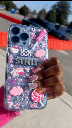 a person holding up a phone case with some stickers on it