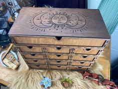 a wooden box with sun and moon designs on it