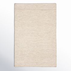 a white rug with small dots on the bottom, and a light gray background behind it