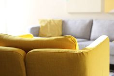 a living room with yellow and gray furniture