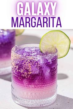 two glasses filled with purple and yellow liquid next to a lime slice on the side