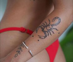 a woman's arm with a scorpion tattoo on the left side of her body