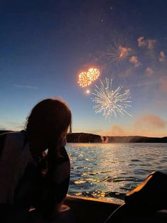 a person sitting in a boat watching fireworks