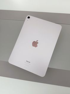 an apple ipad sitting on top of a white table next to a gray and white wall