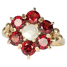 This striking ring holds round cut garnets totalling approx 1.5ct and a moonstone at the centre. All the stones sit in 9carat gold claws. Ring Size: M or 6 1/4 Cluster Diameter: 13mm Height Off Finger: 6mm Weight: 3.5g Garnet And Gold, Cluster Ring, Round Cut, Floral Rings, Moonstone, Garnet, Jewelry Rings, Ring Size, Stone