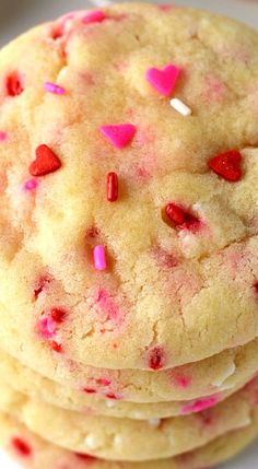 three cookies with pink and red sprinkles are stacked on top of each other