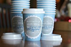 several blue cups sitting on top of a table next to each other with white lids