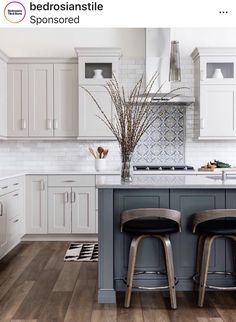 two stools sit at the center of a kitchen island