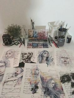 many drawings are spread out on the table