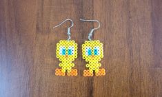 a pair of beaded earrings with an image of a cartoon character on the front