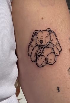 a small tattoo of a teddy bear on the thigh