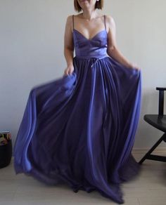 a woman in a purple dress posing for the camera