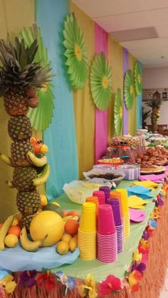 a table topped with lots of food next to a tall pineapple on top of a wooden pole