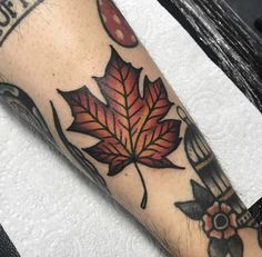 a leaf tattoo on the left forearm