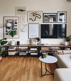 a living room filled with furniture and pictures on the wall above it's coffee table