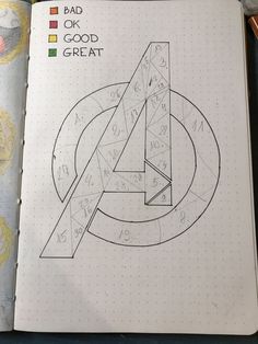 an open notebook with the avengers symbol drawn on it