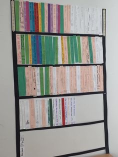 a wall mounted book shelf filled with lots of colorful books on top of a white wall