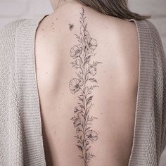 the back of a woman's shoulder with flowers and leaves on her left side