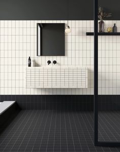 a bathroom with black and white tiles on the walls