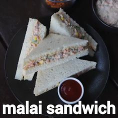 there is a sandwich cut in half on a plate with sauces next to it